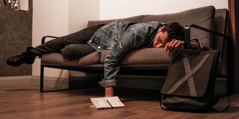 spiaci muž na gauči - únava, vyčerpanosť a slabosť môžu viesť k problémom s erektilnou dysfunkciou
